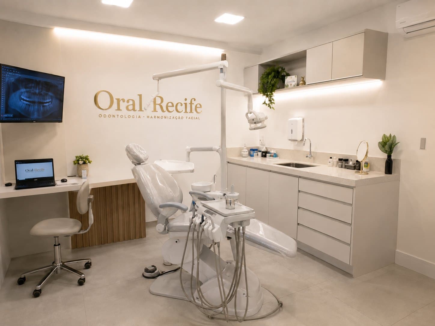 Consultório da Oral Recife, com cadeira odontológica moderna e o logo dourado na parede